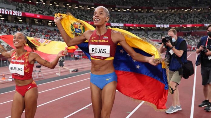 Yulimar Rojas alzando la bandera de Venezuela después de un triunfo