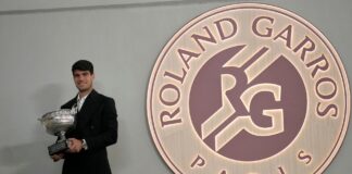 Carlos Alcaraz con su título de Roland Garros posando para los medios