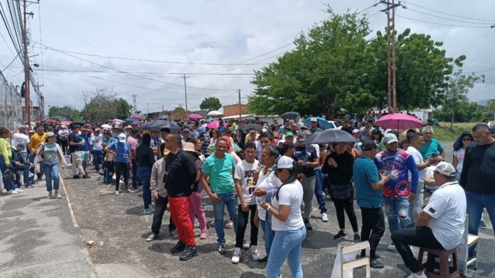 Esperas prolongadas bajo la lluvia en escuela Alicia Pietri de Caldera