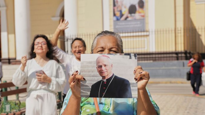 El Papa estadounidense, aparece con una media sonrisa y llevando la cruz pectoral dorada. Su firma es el nombre en latín “Leo” y con la abreviatura “pp” antes del XIV